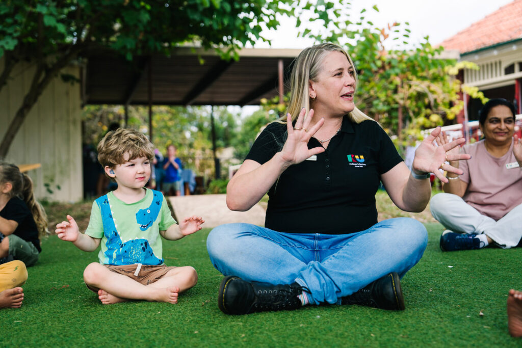 KU Briar Cottage childcare educator singing a song with some children