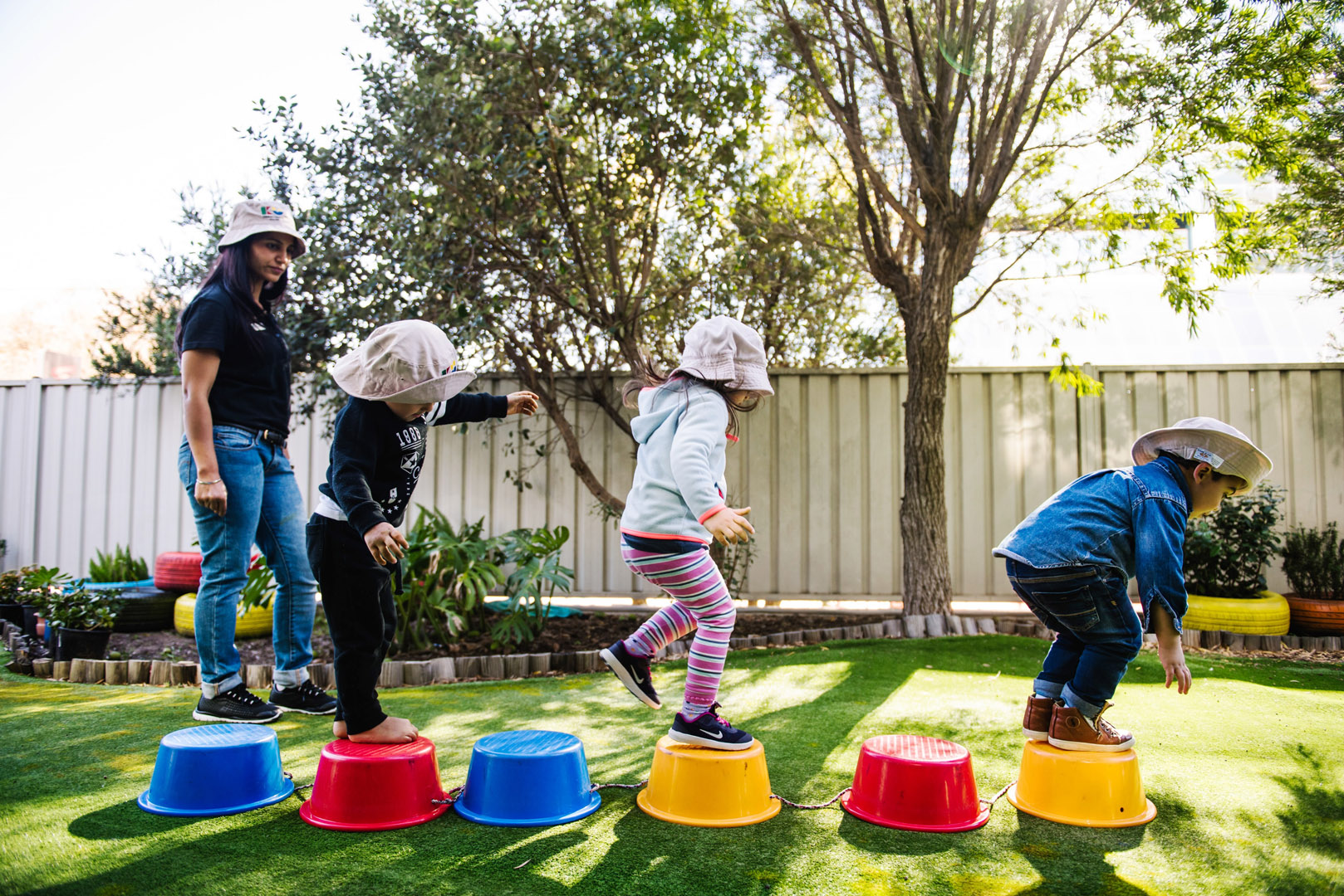 KU Bankstown childcare educator supervising children playing outdoors