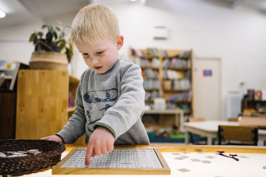 Child counting number tiles at KU Berowra childcare