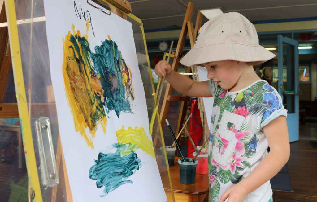 Child doing a painting at KU Berowra childcare