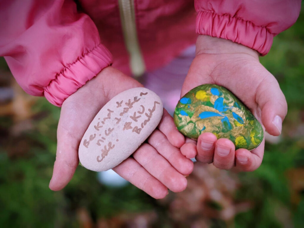 Child showing some painted rocks at KU Braddon childcare