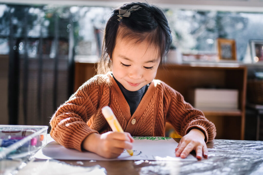 Child doing a drawing at KU Cabramatta AMEP childcare