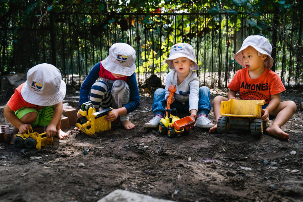 Children playing with toy trucks at Kooinda Workbase Childcare