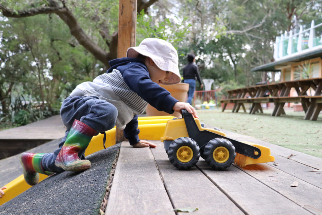 Child playing with a toy digger at KU Cammeray childcare