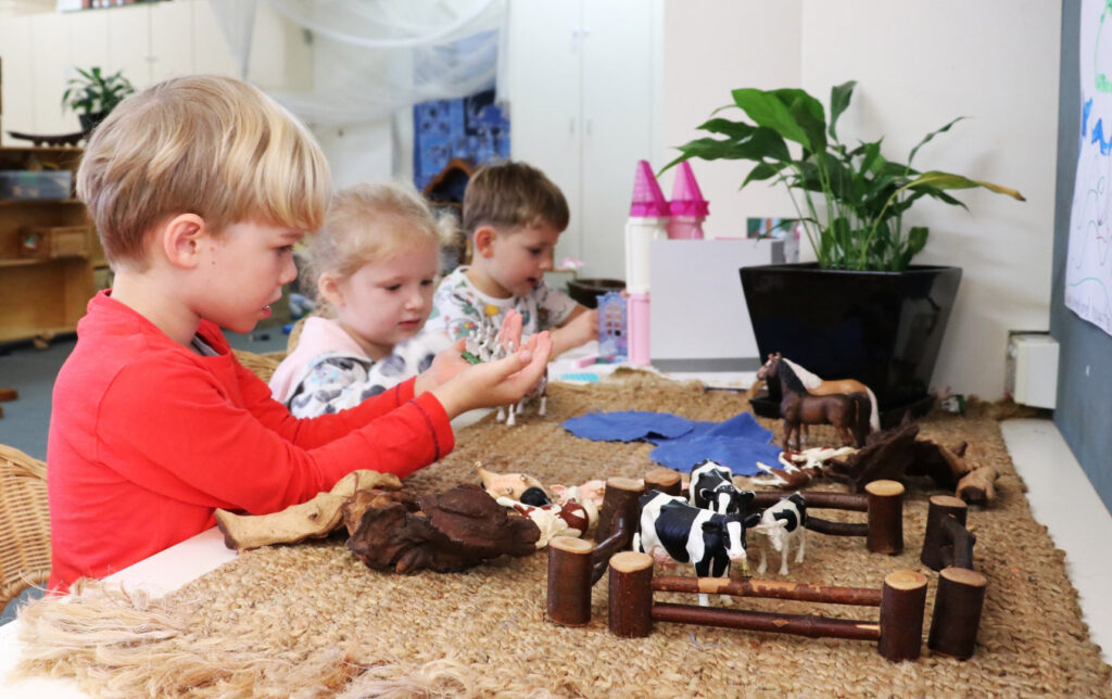 Children playing with mini farm animals at KU Castlecrag childcare