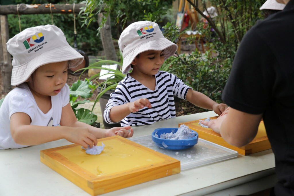 KU Chester Hill childcare educator making recycled paper with some children