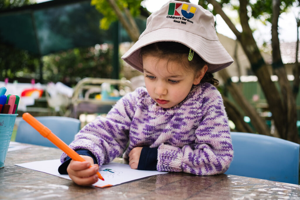 Child doing a drawing at KU Croydon childcare