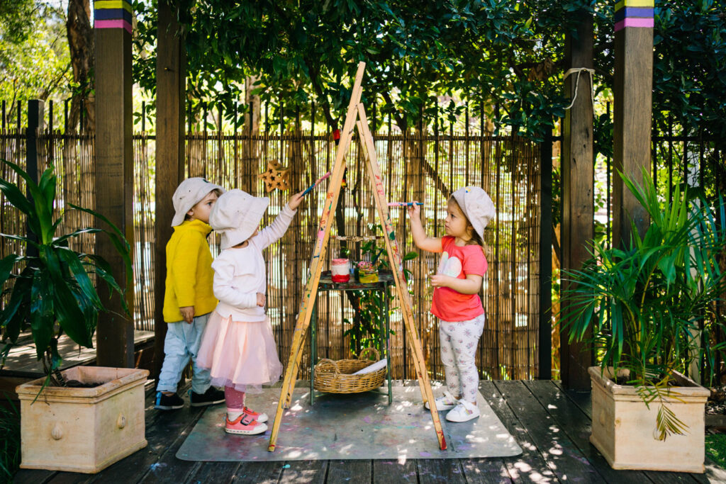 Children doing some painting outdoors at KU Union childcare