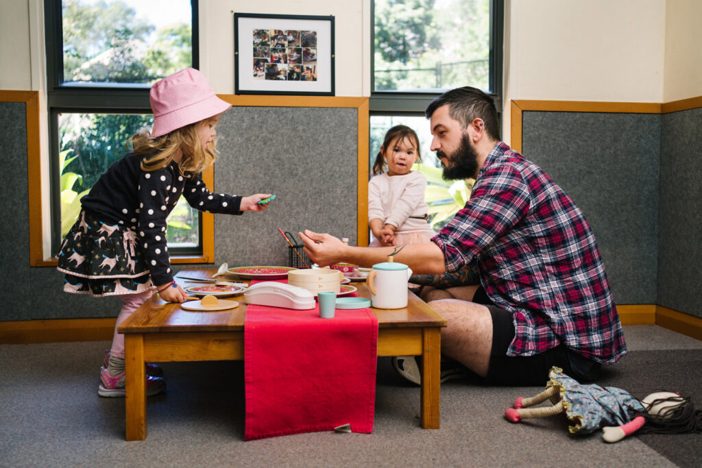 KU Union childcare educator and children playing with a dining set