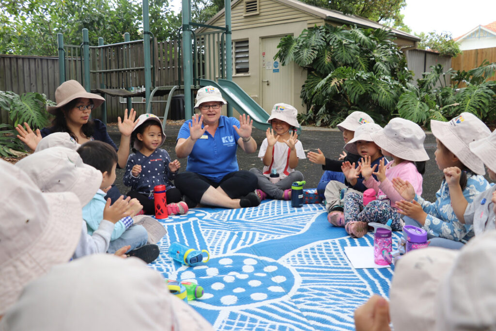 KU Eastwood childcare educators with children sitting in a circle