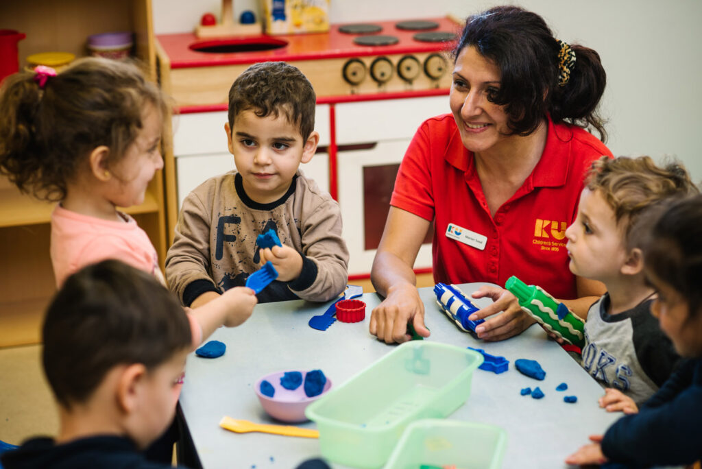 KU Fairfield AMEP childcare educator and children playing with playdough