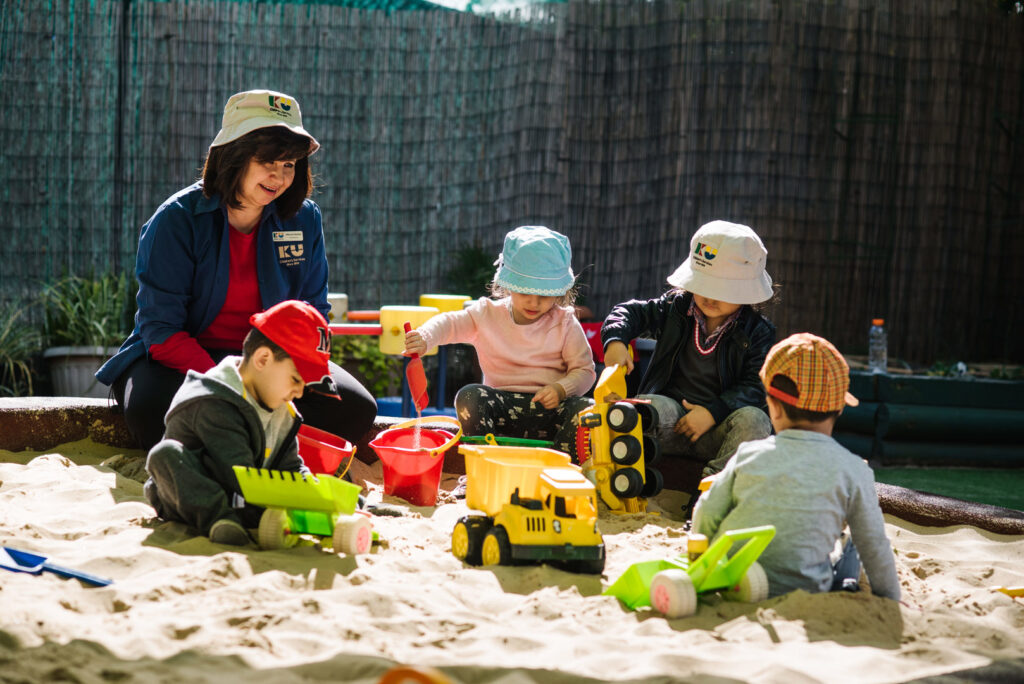 KU Fairfield AMEP childcare educator supervising children playing in the sand