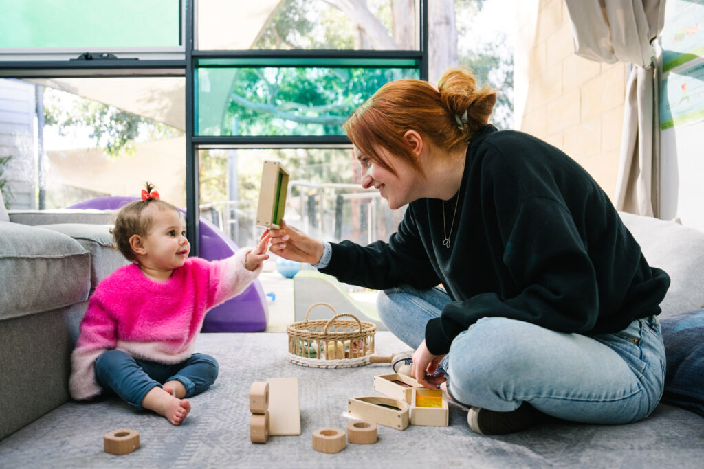 KU Monash childcare educator interacting with a child