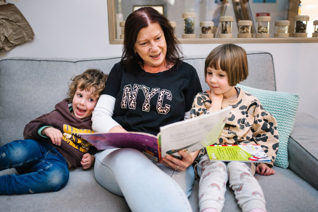 KU Monash childcare educator reading a story to children