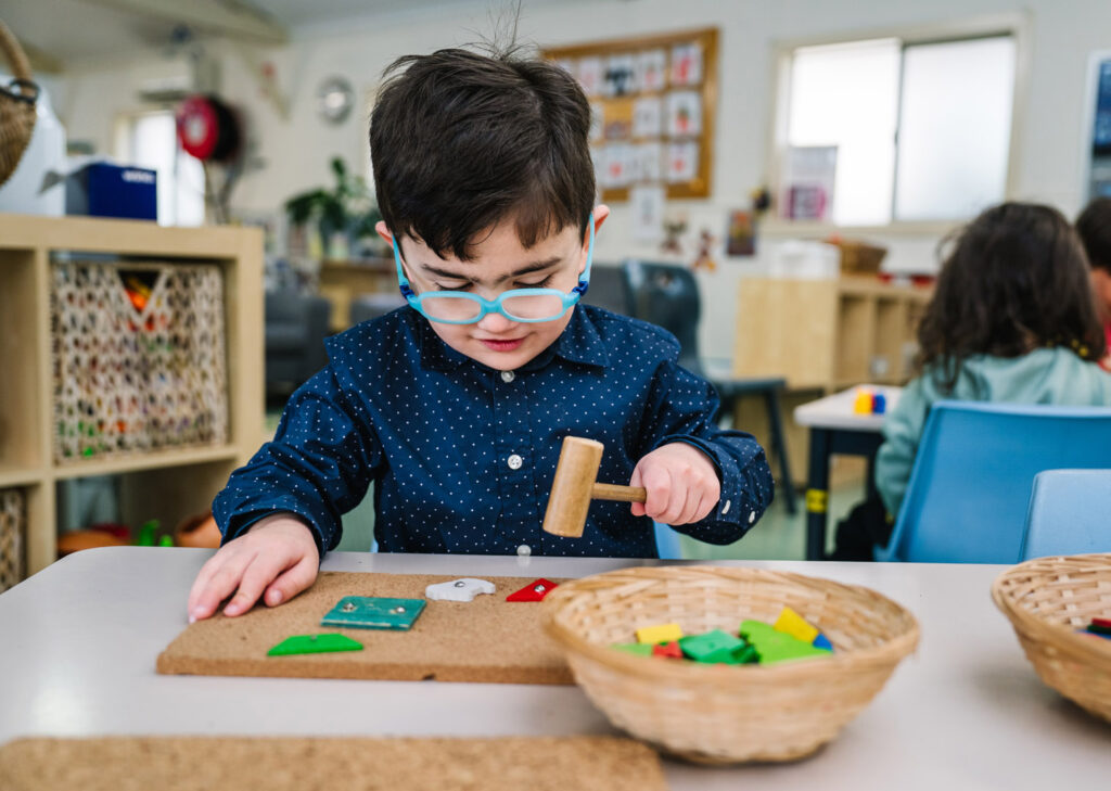 Child with some blocks and a toy hammer at KU Georges Hall childcare