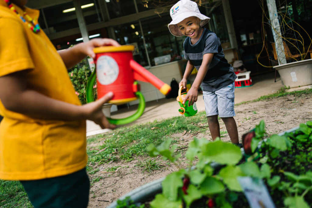 Children watering the garden at KU Hebersham childcare