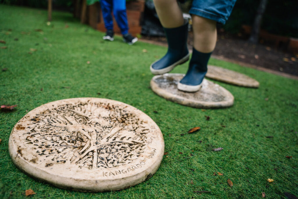 Children walking on stepping stones at KU Grevillea childcare