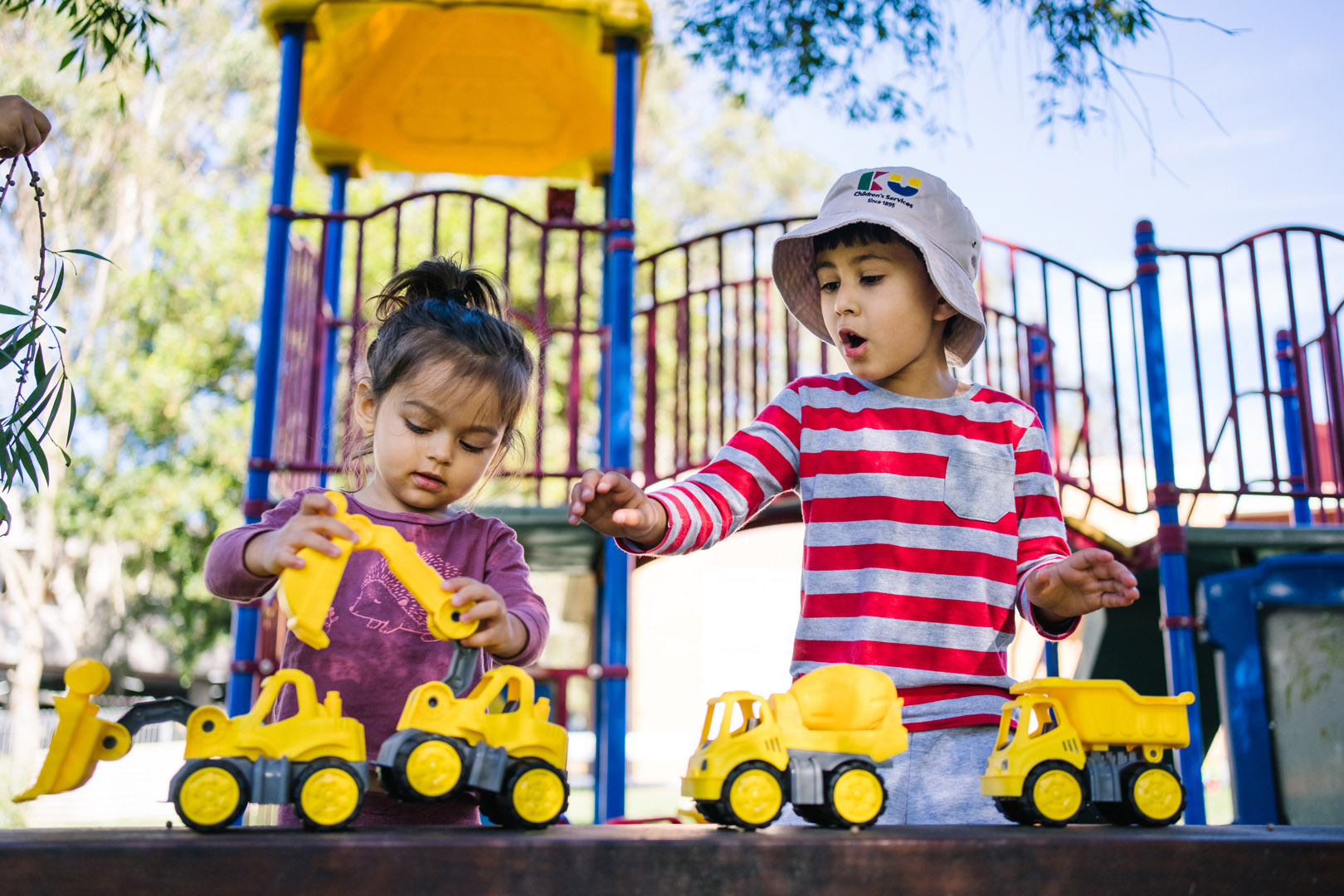 Children playing with toy trucks at KU NSP Jesmond Neighbourhood childcare