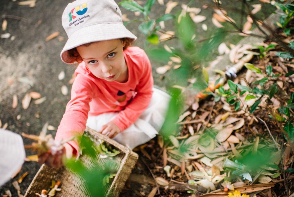 Child collecting leaves at KU Killara Park childcare