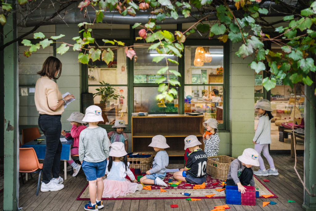 KU Osborne childcare educator supervising children playing outdoors