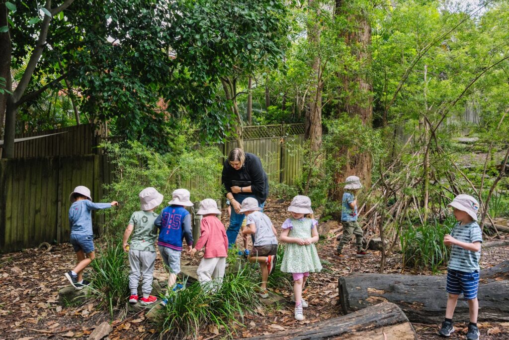 KU Osborne childcare educator supervising children playing outdoors