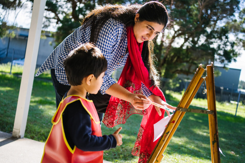 KU NSP Maryland Public School childcare educator and a child doing a painting