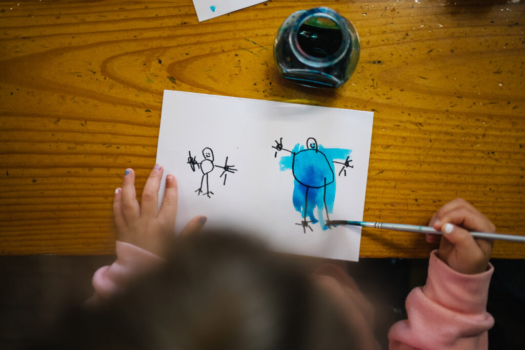 Child doing some painting at KU's The Joey Club childcare