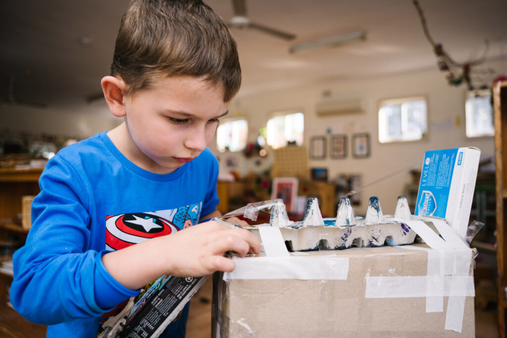 Child doing some arts and craft at KU Mayfield childcare