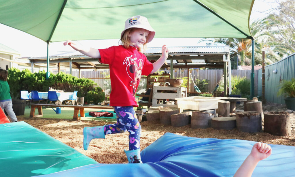 Child playing on equipment at KU Merewether childcare