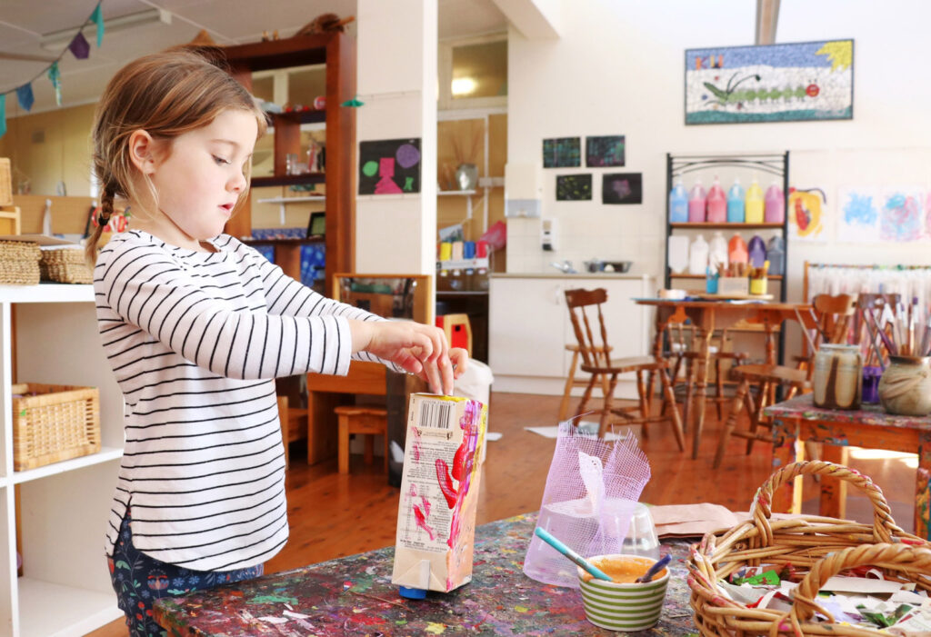 Child doing some arts and craft at KU Merewether childcare