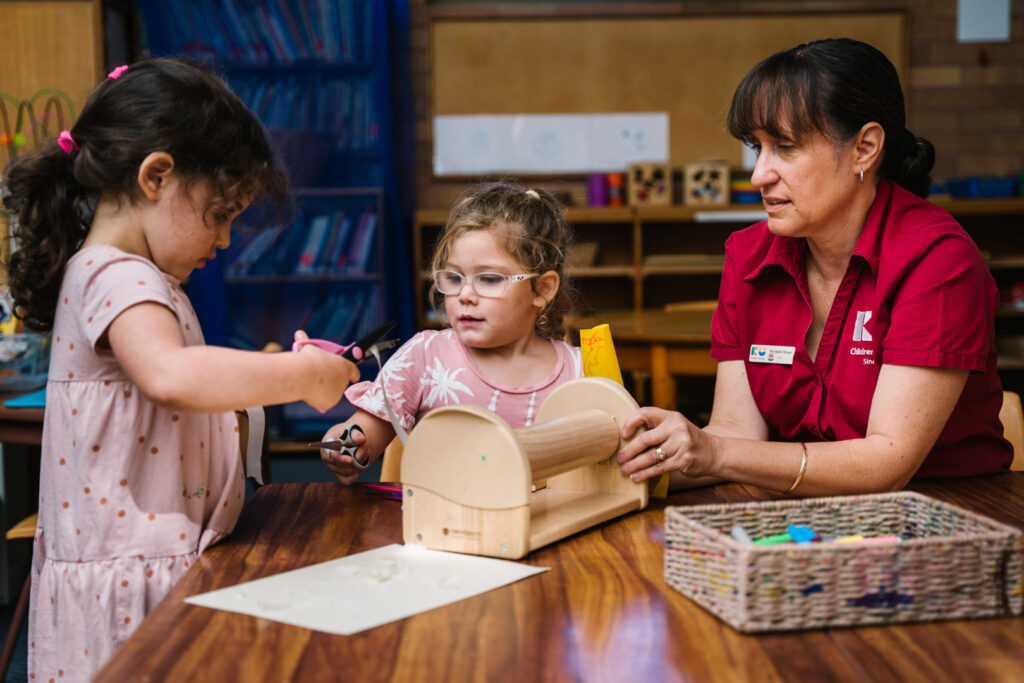 KU Merewether childcare educator and some children doing arts and craft