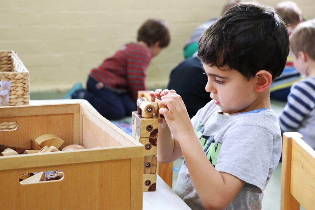 Child playing with a block toy at KU Mosman childcare