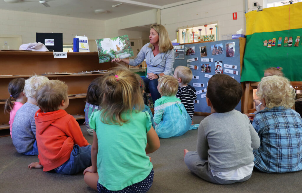 KU Newport childcare educator reading a story to children