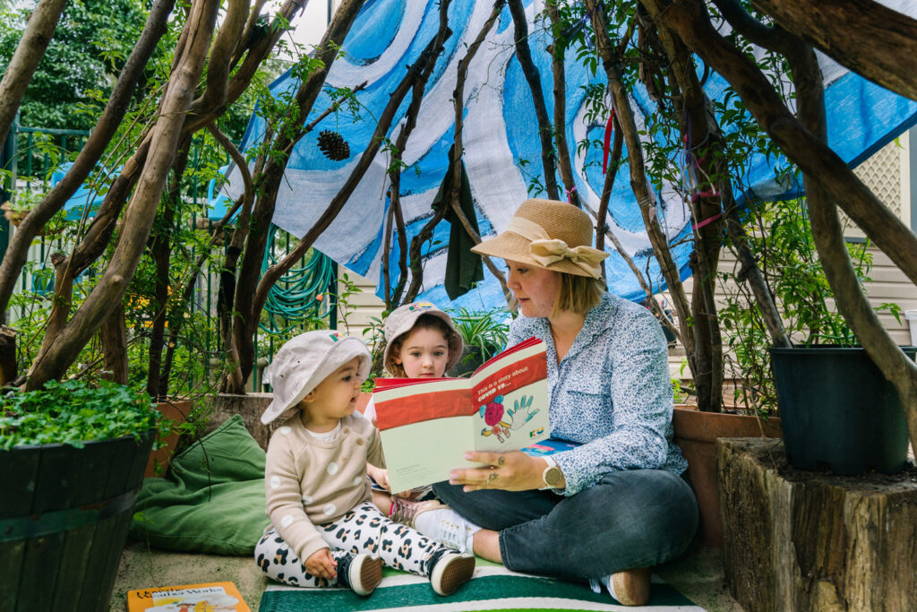 KU Carillon Avenue childcare educator reading a story to some children