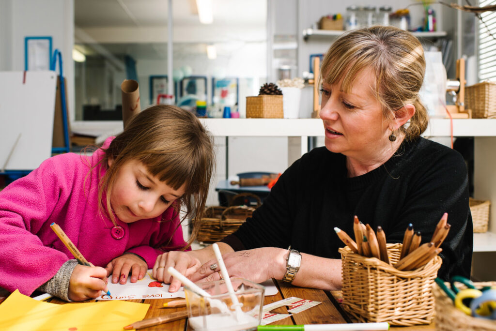 KU Bilya Gulyangarri childcare educator writing and drawing with a child