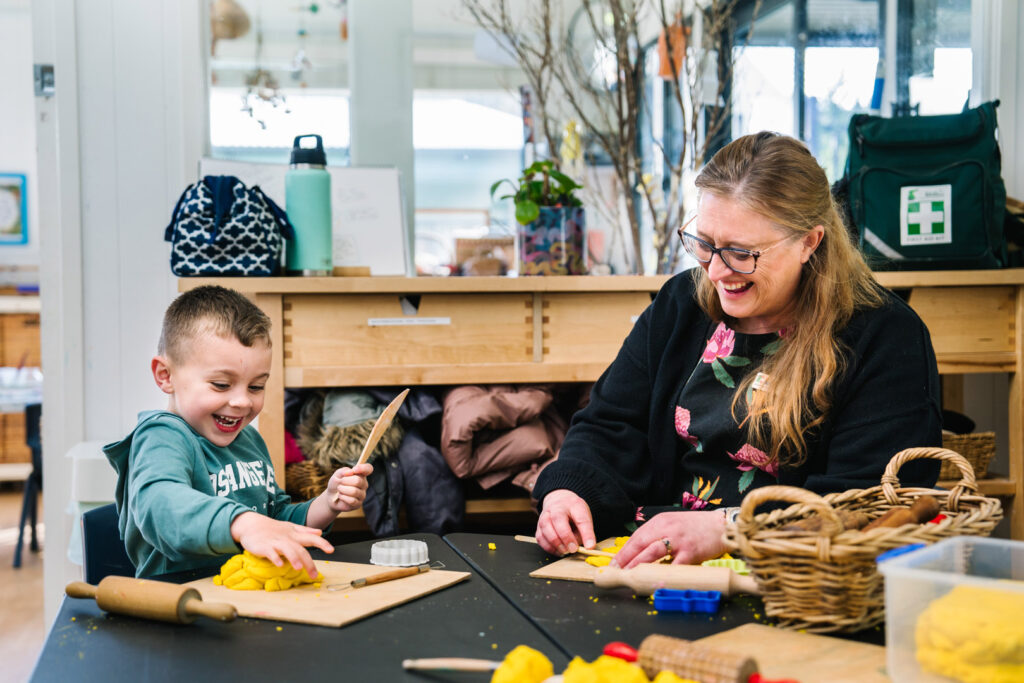 KU Bilya Gulyangarri childcare educator sculpting with playdough with a child