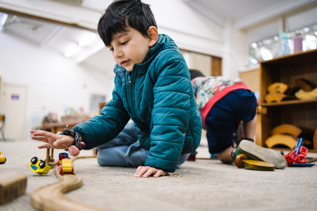 Child playing with a train set at Kira childcare