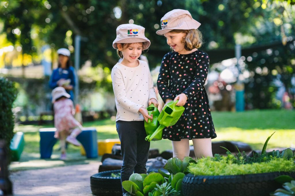 Children watering the vegetable patch at KU Petersham childcare