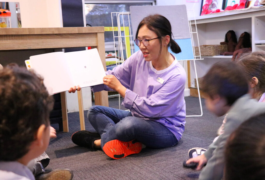 KU Maybanke childcare educator reading a story to children