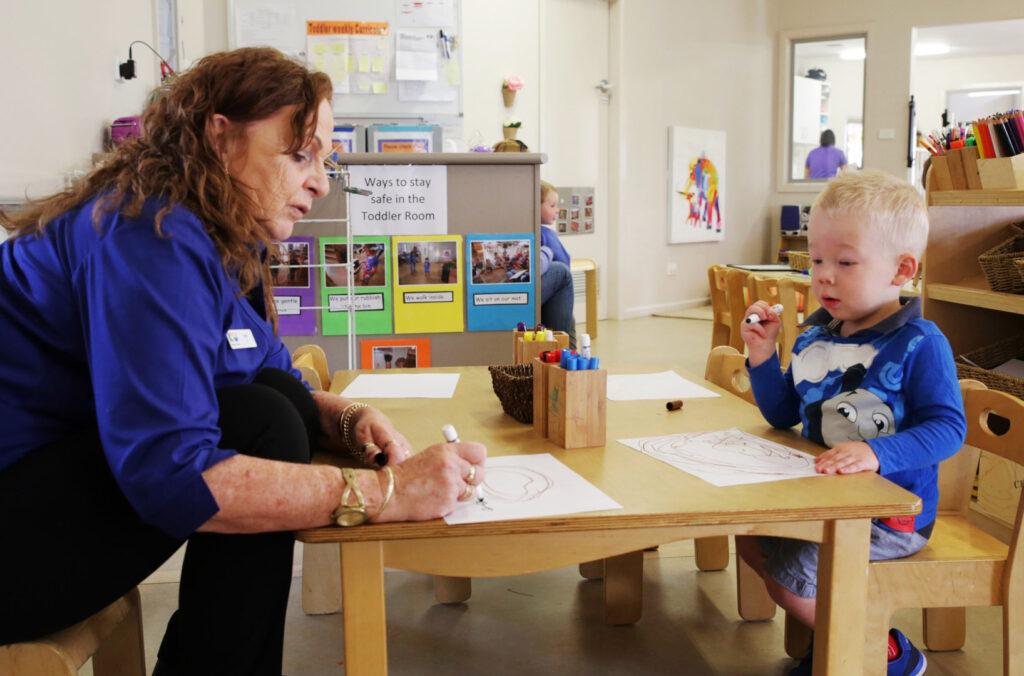 KU Queanbeyan childcare educator doing some drawings with a child