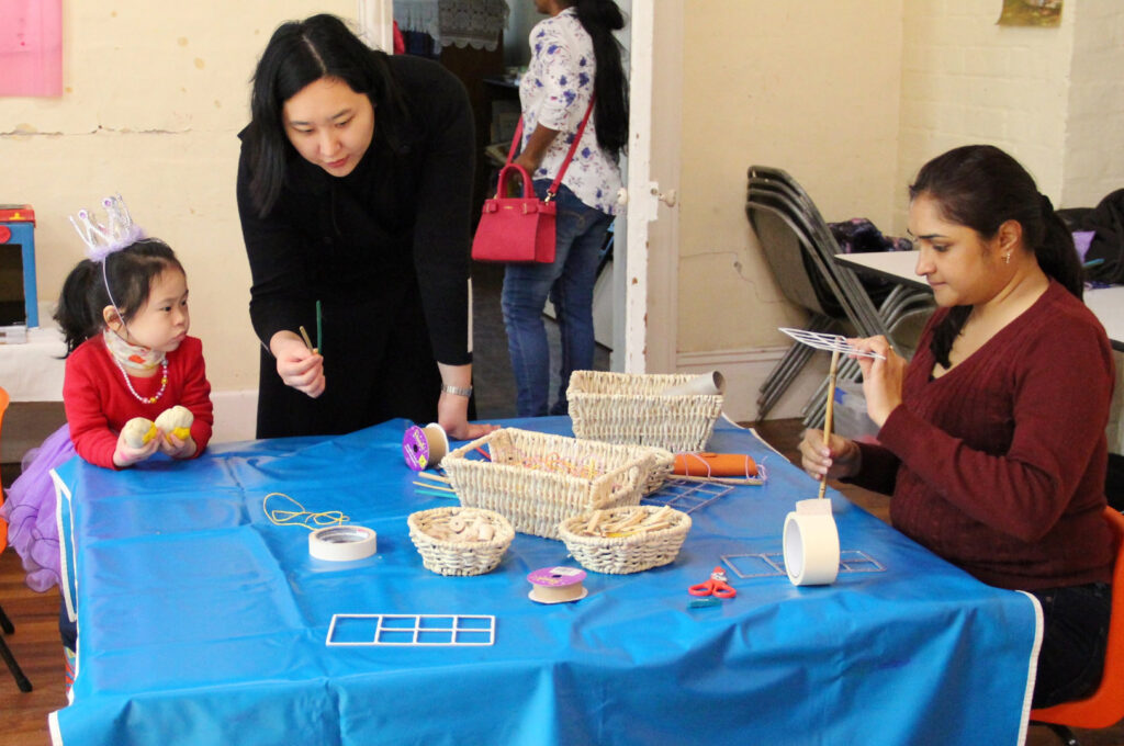 KU IWSP Rhodes childcare educators doing arts and craft with a child