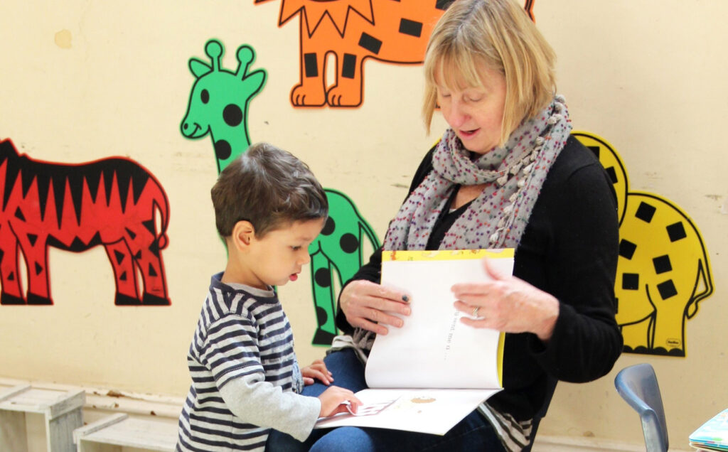 KU IWSP Rhodes childcare educator reading a story with a child