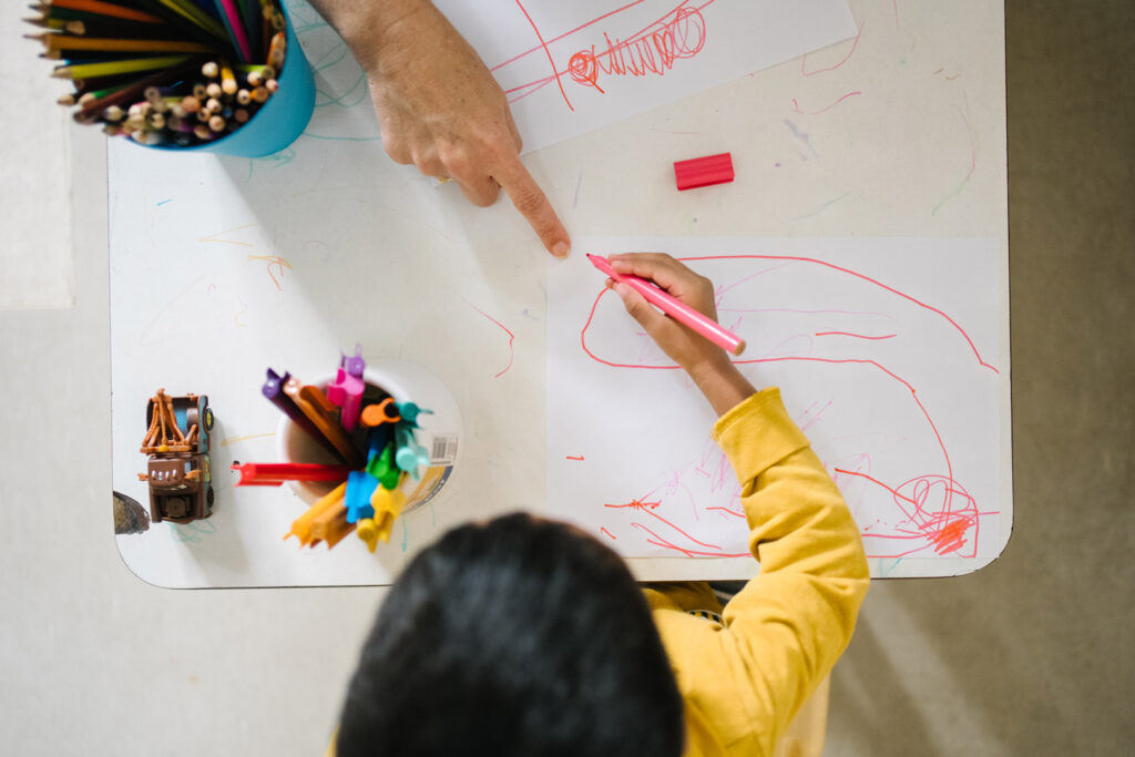 KU The Chase childcare educator and a child doing a drawing