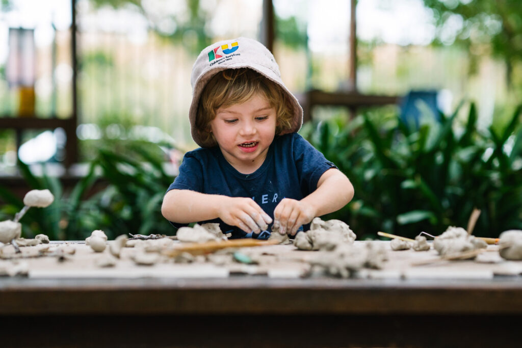 Child sculpting with clay at KU Rushcutters Bay childcare