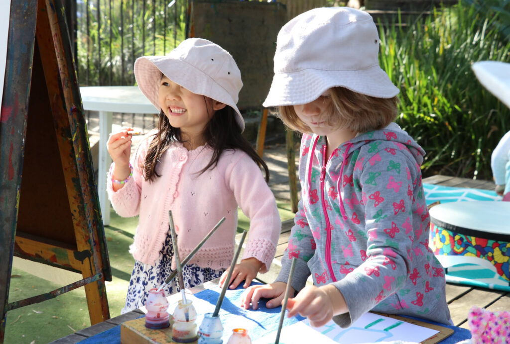 Children doing a painting at KU South Turramura childcare