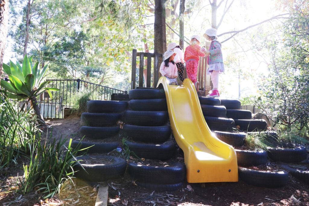 Children playing on the slide at KU South Turramura childcare