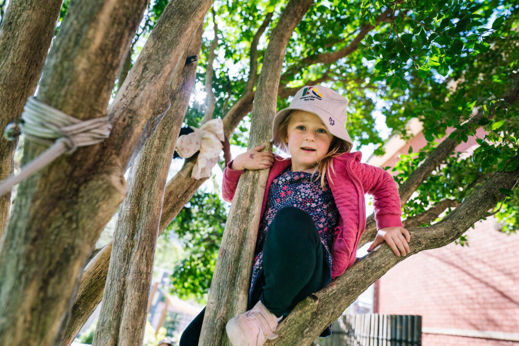 Child climbing a tree at KU St Ives Barra Brui childcare