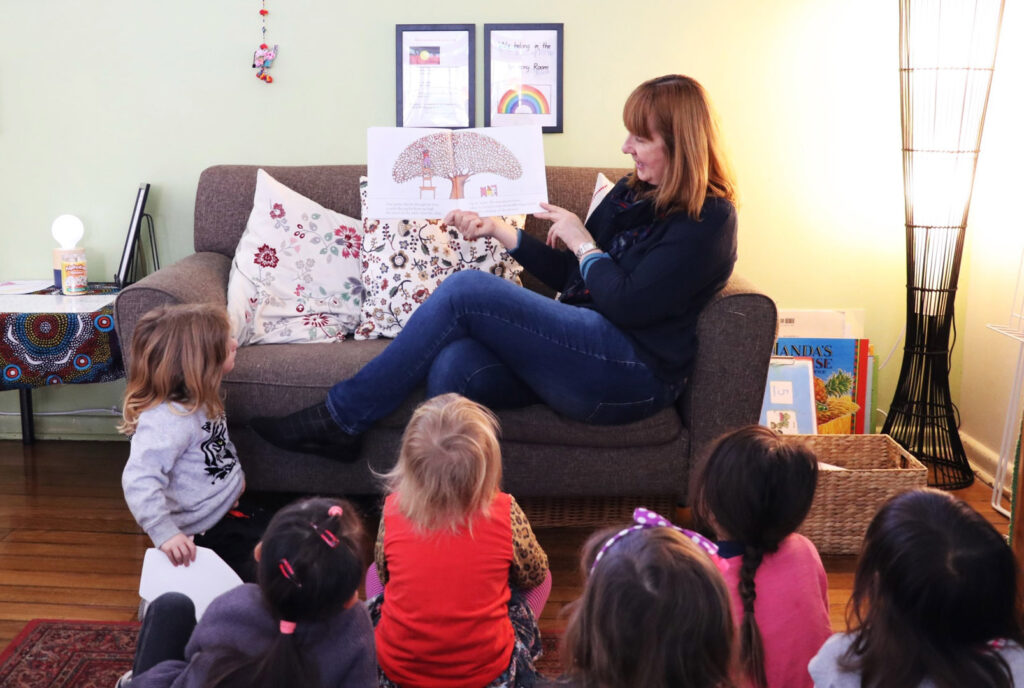 KU John J. Carroll childcare educator reading a story to children