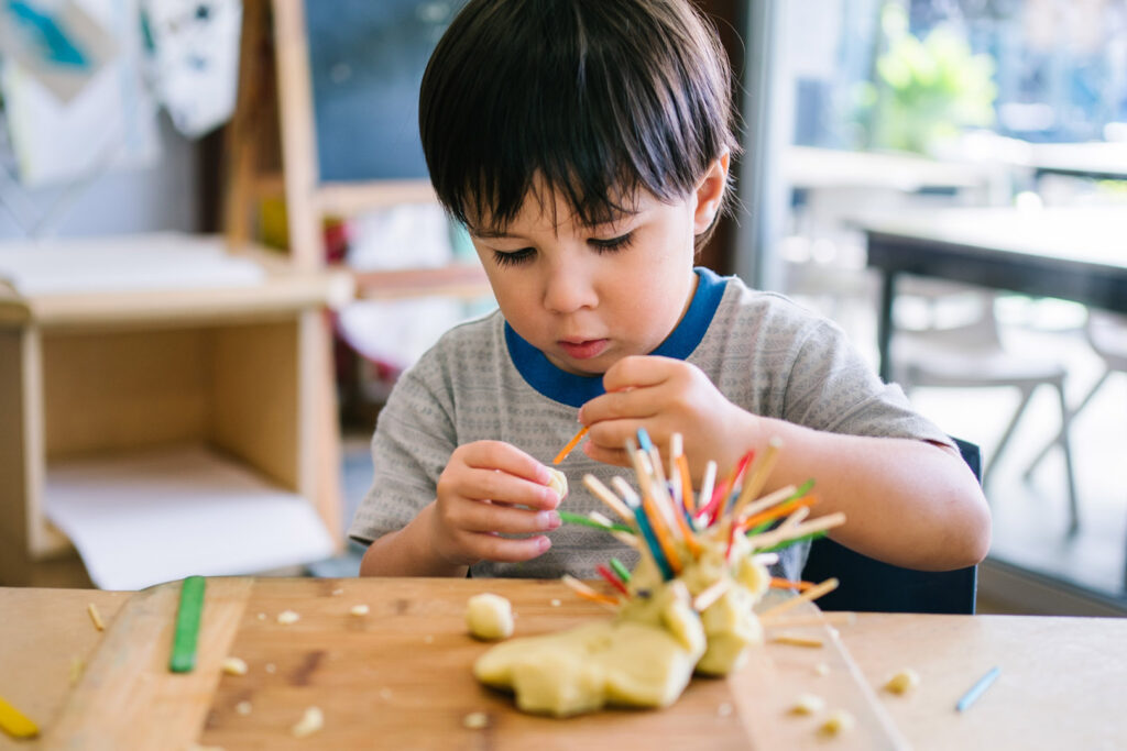 Child playing with playdough at KU Sutherland childcare