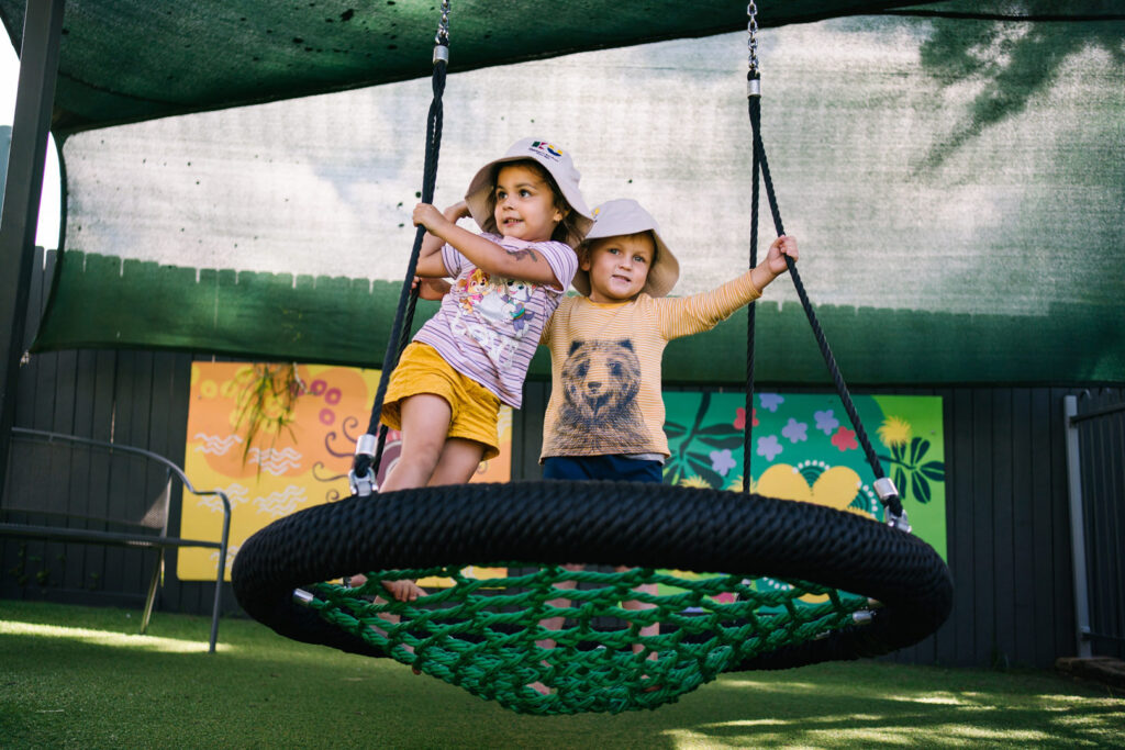 Children on a swing at KU Sutherland childcare